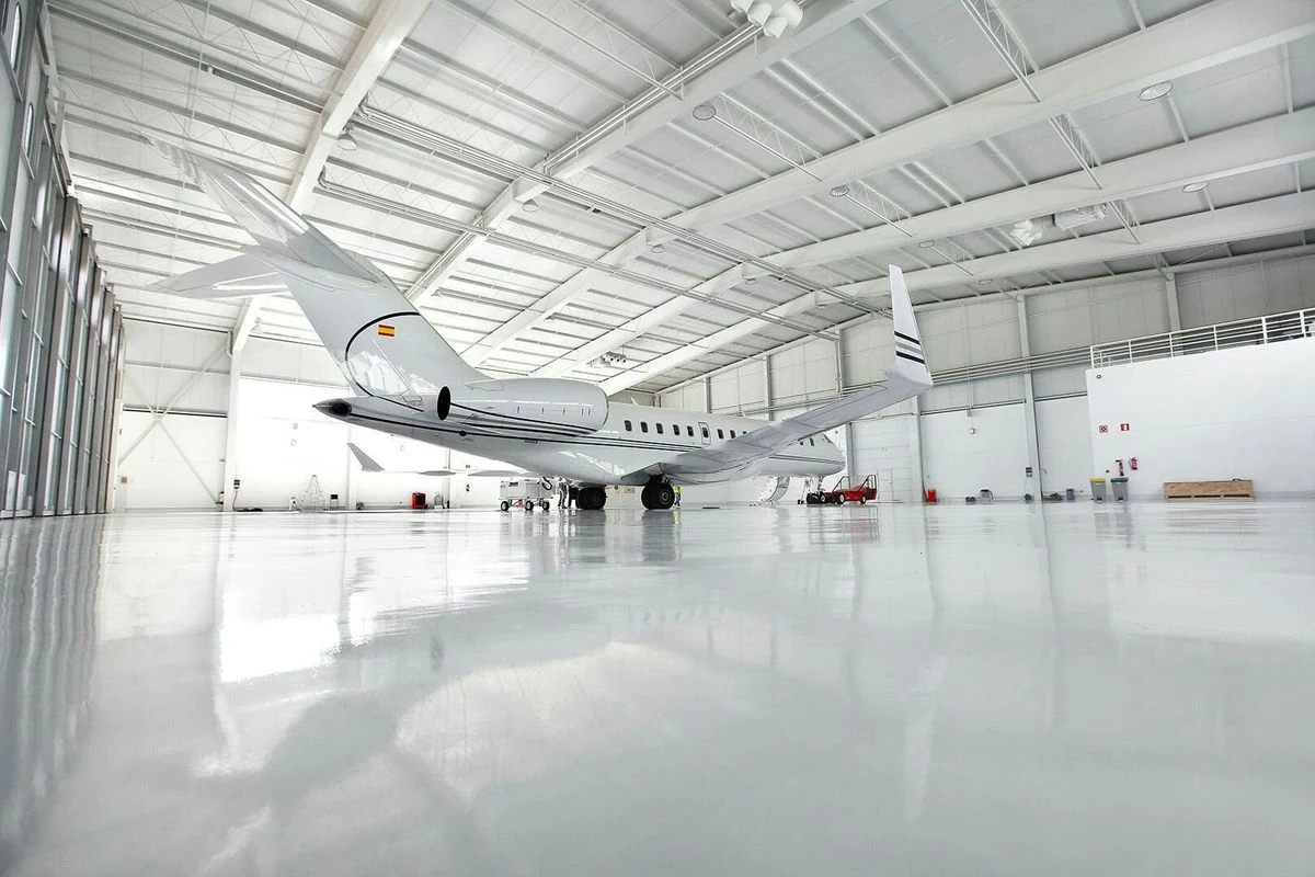 Bright white aviation hangar with a business jet and a clean polished floor