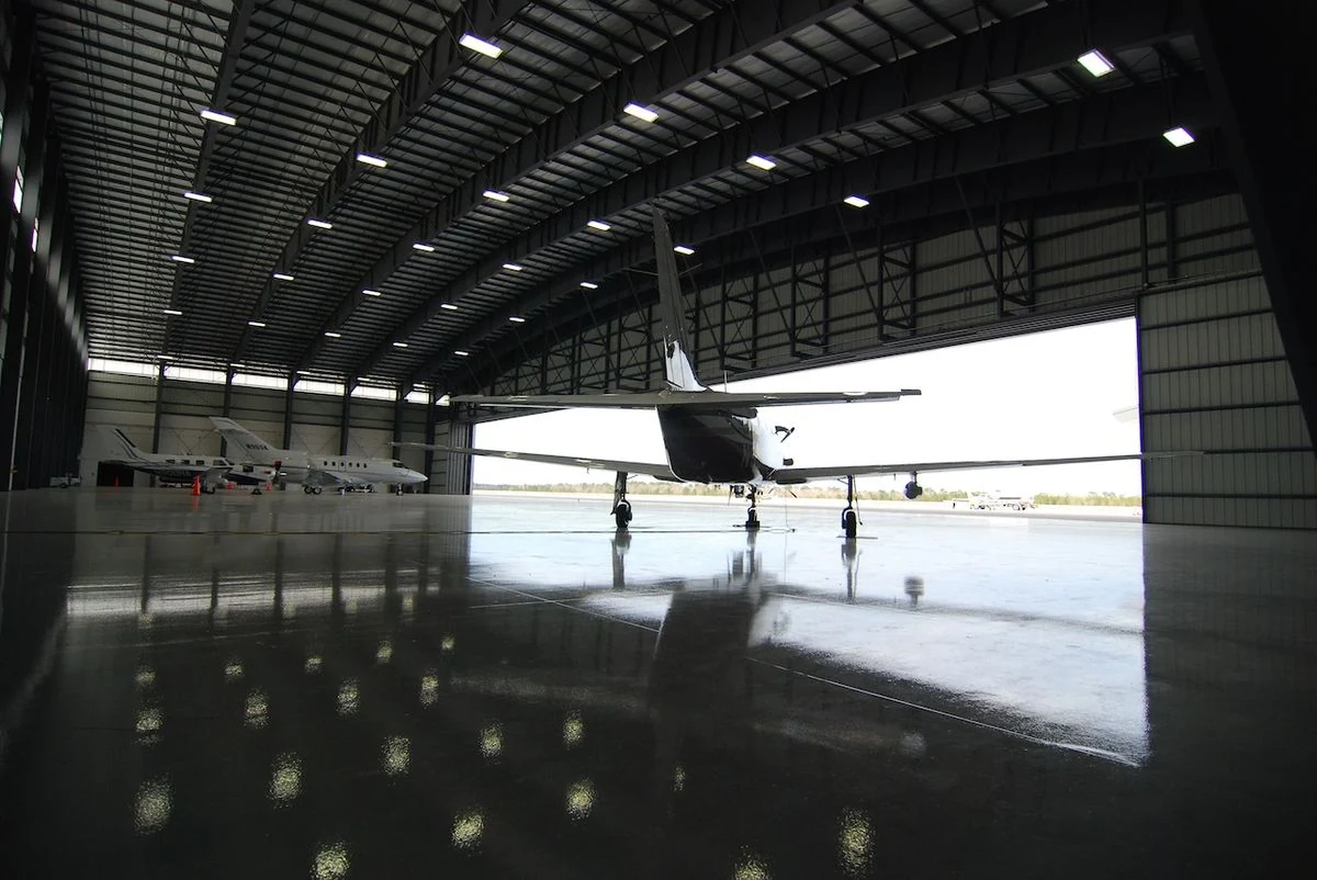Professional aircraft hangar floor care with multiple aircraft and a reflective cleaned floor
